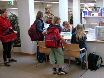 Kinder stehen bei der Ausweisausgabe in der Bücherei schlange