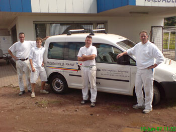 Das Foto zeigt die Firma Knauf und Mitarbeiter vor dem Firmenwagen