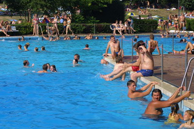 Das Foto zeigt das Freibad Oktopus in Siegburg , viel blaues Wasser und viele Badegäste