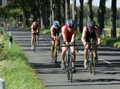 Das Foto zeigt 4 Rad-Rennfahrer auf der Straße