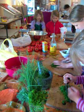 Kinder beim Kochen mit frischen Kräutern und Gemüse