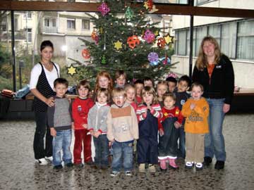 Die Kinder der Tagesstätte Deichmäuse vor dem geschmückten Baum im Foyer des Rathauses