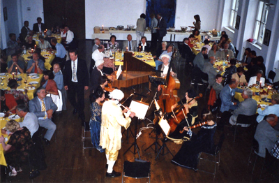 Das Foto zeigt ein Buffetkonzert im Museum mit den Gästen und den Musikern