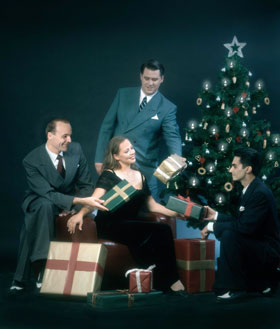 Das Bild zeigt das Swing Dance Orchestra vor einem Weihnachtsbaum und Geschenken