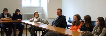 Das Bild zeigt den Abt Raphael im Gespräch mit Schülern