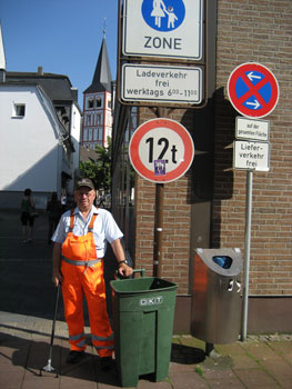 Das Bild zeigt Adolf Fischer mit Zange und Mülltonne