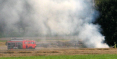 Das Bild zeigt ein Feuerwehrauto im Qualm