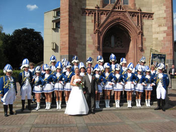 Das Bild zeigt die Funken Blau-Weiß mit dem Brautpaar vor der Kirche