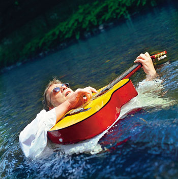Martin C. Herberg mit Gitarre im Wasser
